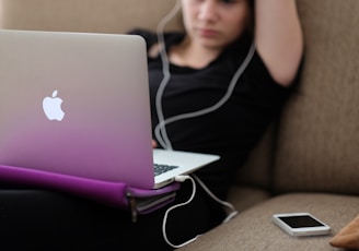 woman sitting on sofa with MacBook Air