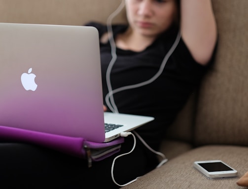 woman sitting on sofa with MacBook Air