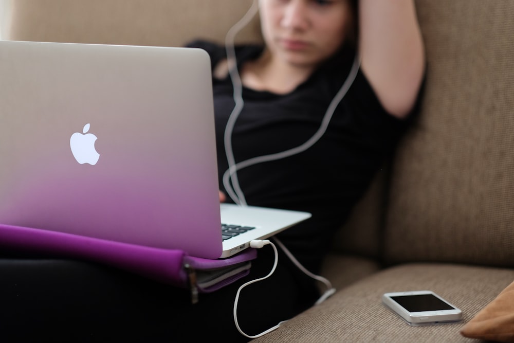 Frau sitzt mit MacBook Air auf dem Sofa