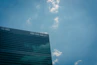 A clean office building with gleaming windows reflecting the blue sky.