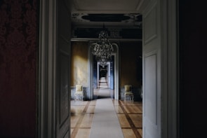 opened white wooden door near chandelier