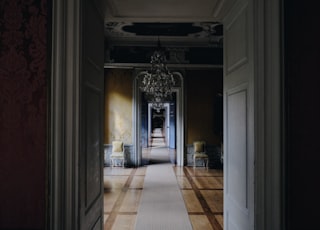 opened white wooden door near chandelier