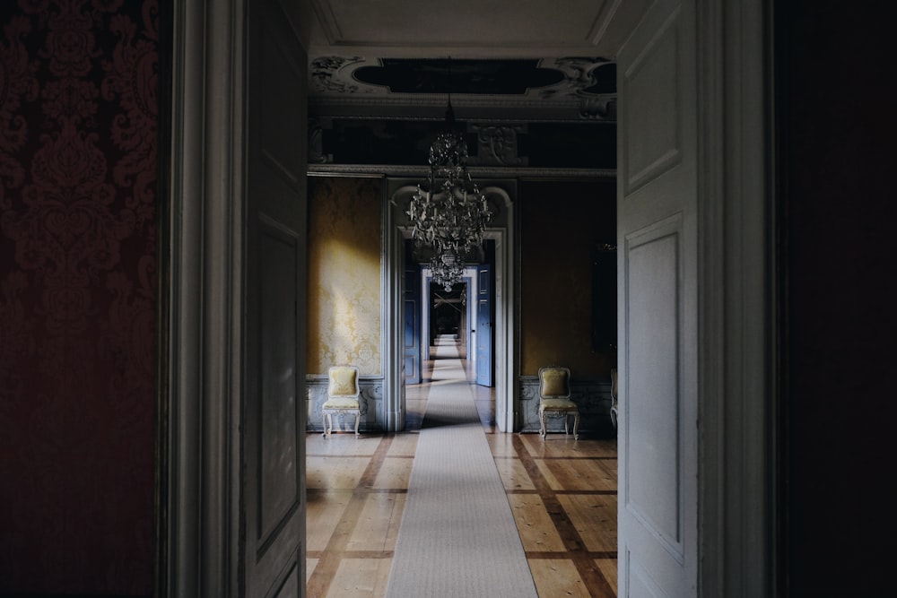 opened white wooden door near chandelier