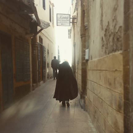 Character glance exchanged in shadowed alley, hinting at deep connections.