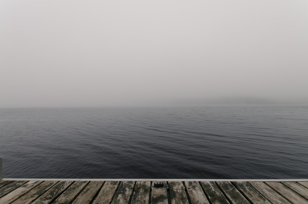 a wooden dock with a body of water in the background