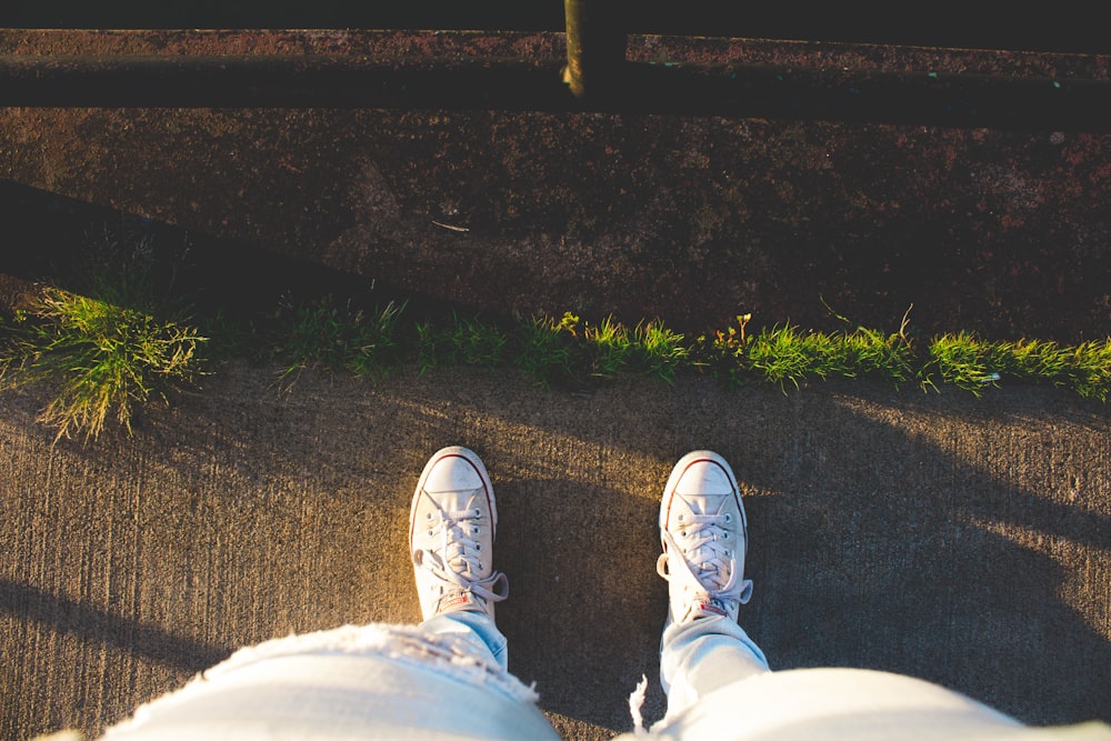 person wear sneakers standing on road