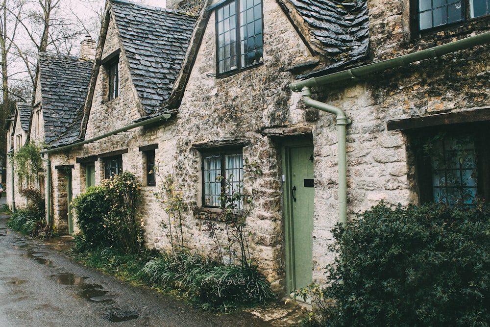 Maison en béton blanc et brun près des arbres pendant la journée