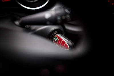 A locksmith programming a new car key with specialized equipment inside a vehicle.