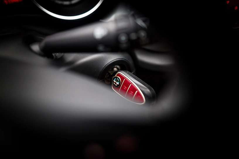 A skilled locksmith using advanced tools to program a car key inside a modern vehicle.