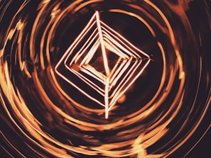 Dynamic shot of a glowing orange geometric shape cutting through a shadowy space.