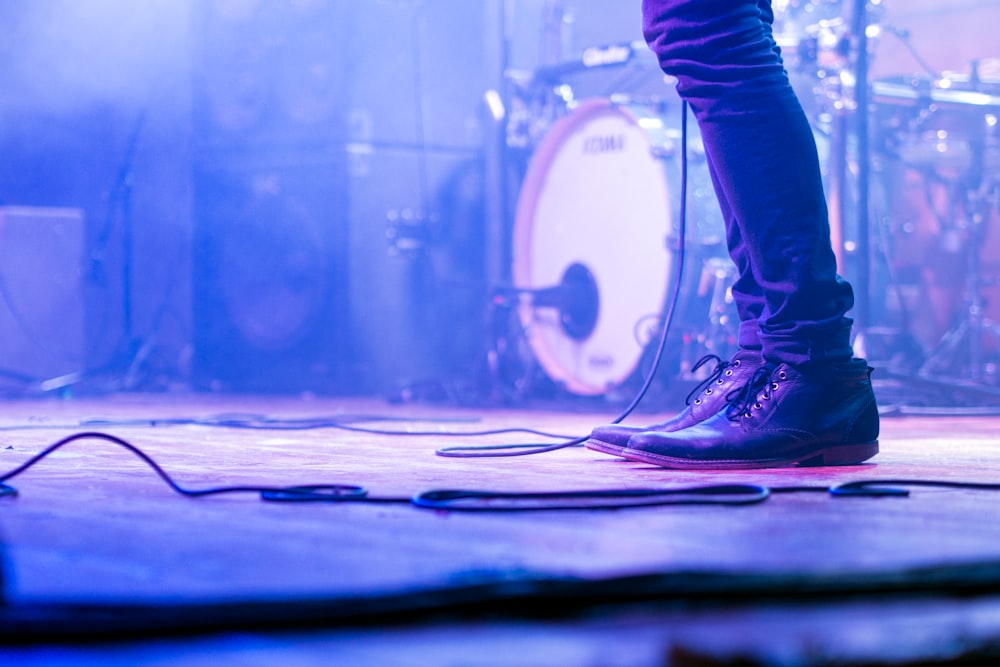 A low shot of a musician's jeans and shoes on a stage
