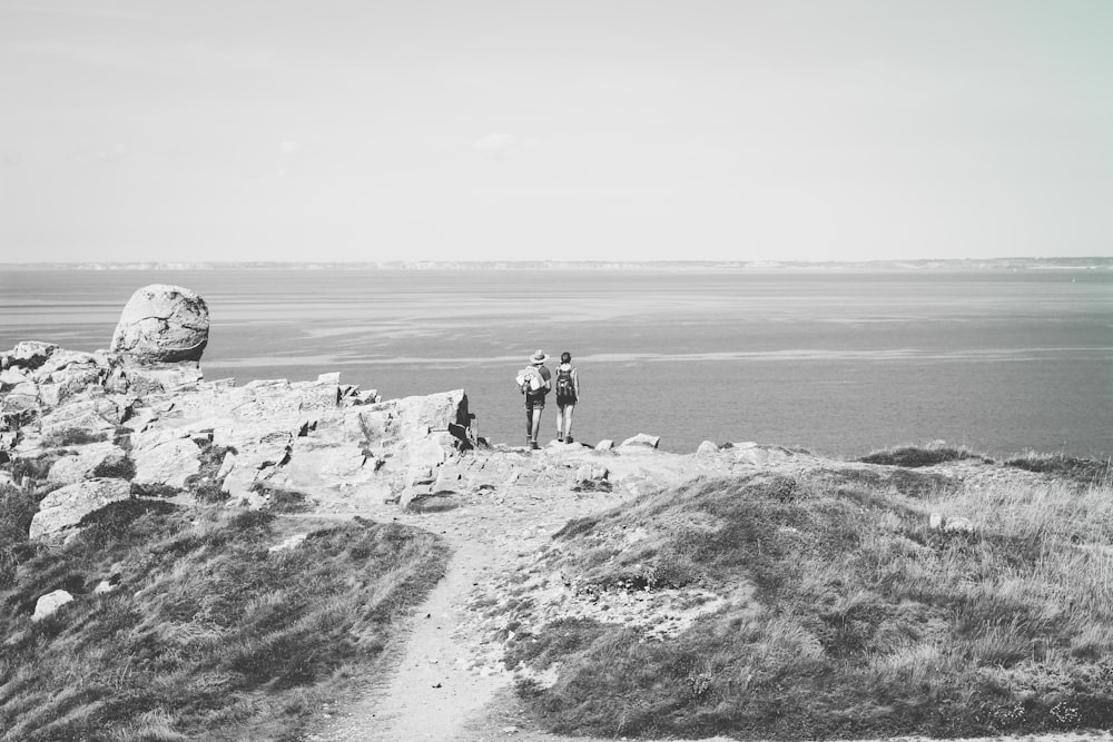 a couple of people standing on top of a hill