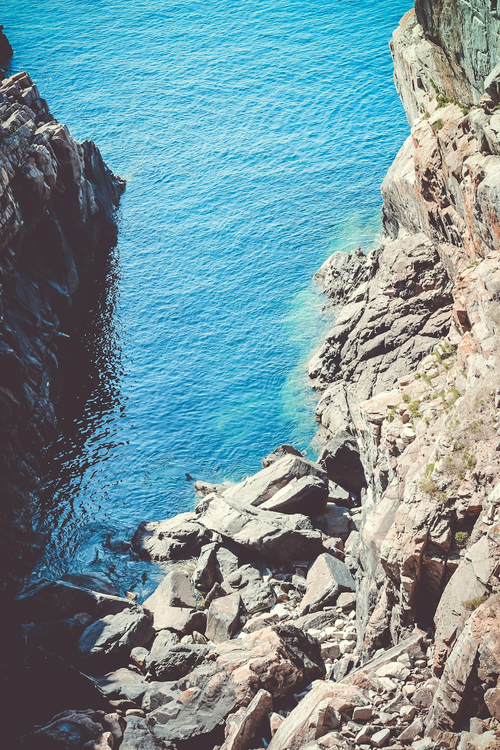 a person standing on a rocky cliff overlooking the ocean
