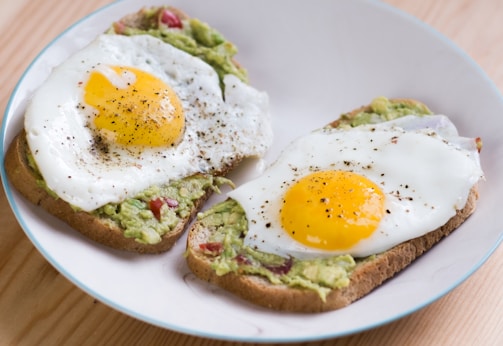 A minimalist plate featuring a perfectly cooked sunny-side-up egg with avocado slices.