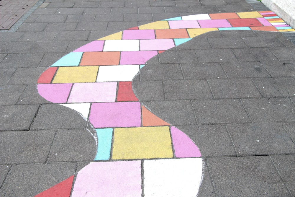 A curvy section of bricks painted with various light colors.