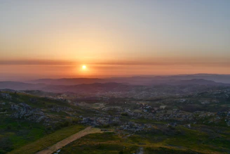 A serene Andalusian landscape at sunset with soft terracotta and olive green hues blending into the sky.