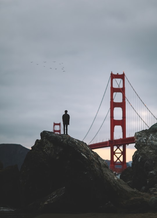 silhouette of man standing on rock near Golden Gate bridge in Golden Gate Bridge United States