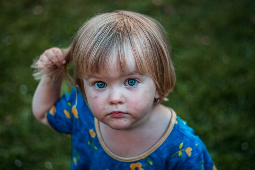 Fotografia de foco seletivo da menina segurando seu cabelo