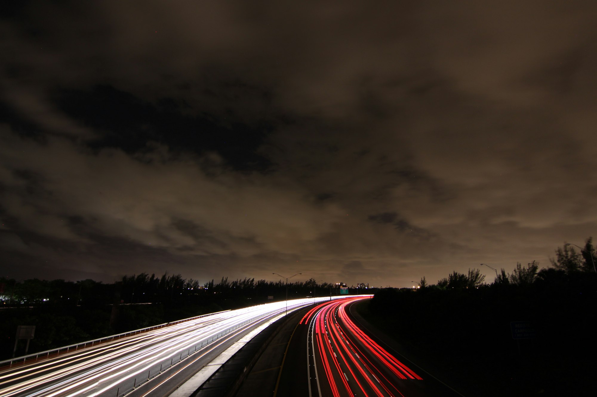 Timelapse photography of passing cars on road at nighttime