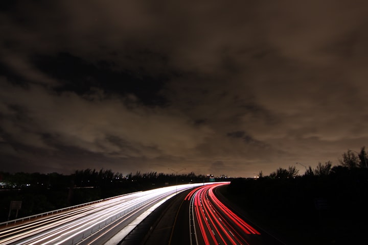 Timelapse image shows streaks of light from red and white car lights.