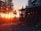 A family enjoying a sunset view from a rustic cabin porch.
