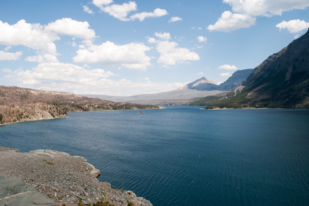 Mar azul perto da montanha verde sob o céu azul durante o dia