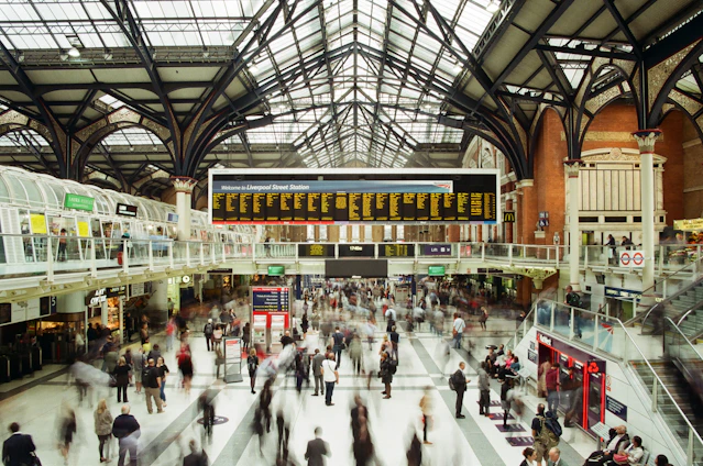 A vibrant photo of a traveler consulting a map with a backdrop of an Indian railway station bustling with activity.