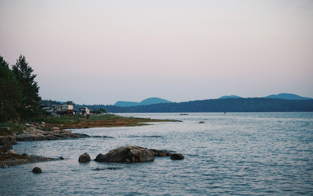 a body of water surrounded by trees and mountains