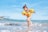 girl playing beside body of water during daytime