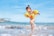 girl playing beside body of water during daytime