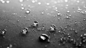 Close-up on the textured fabric of high-end swimwear, water droplets adding a tactile freshness.