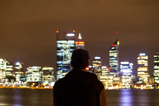 Silhouette of a man looking at a glowing city skyline symbolizing future goals