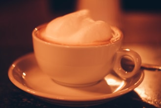 A serene shot of a cappuccino in a white cup on a beige table, with soft natural light highlighting the creamy foam art.