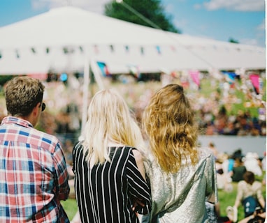 three person's standing front of field