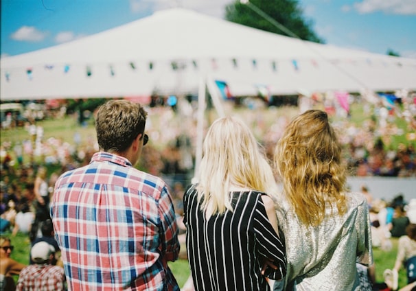 three person's standing front of field