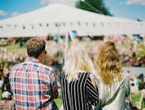 three person's standing front of field