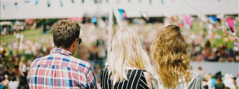 three person's standing front of field