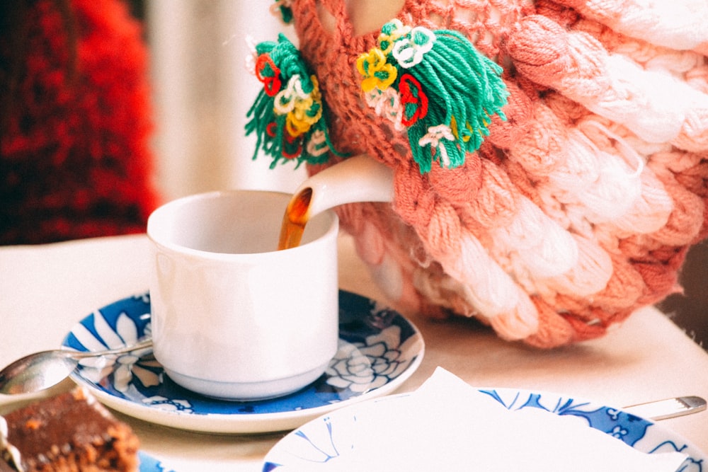 Selektive Fokusfotografie einer Person, die Teetasse einschenkt