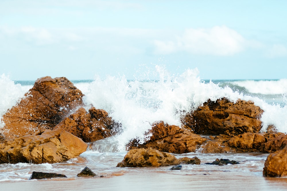 high waves crashing on rock formation at daytime