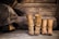 A pair of stylish long boots placed next to a pair of short boots on a wooden floor.