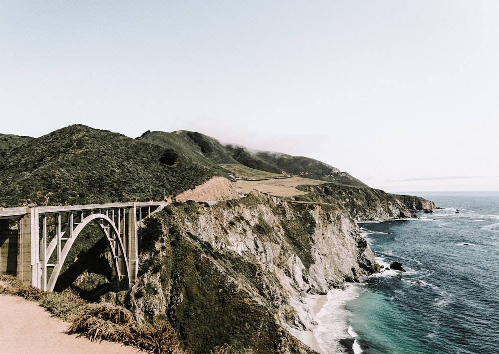 photo of white bridge on mountain