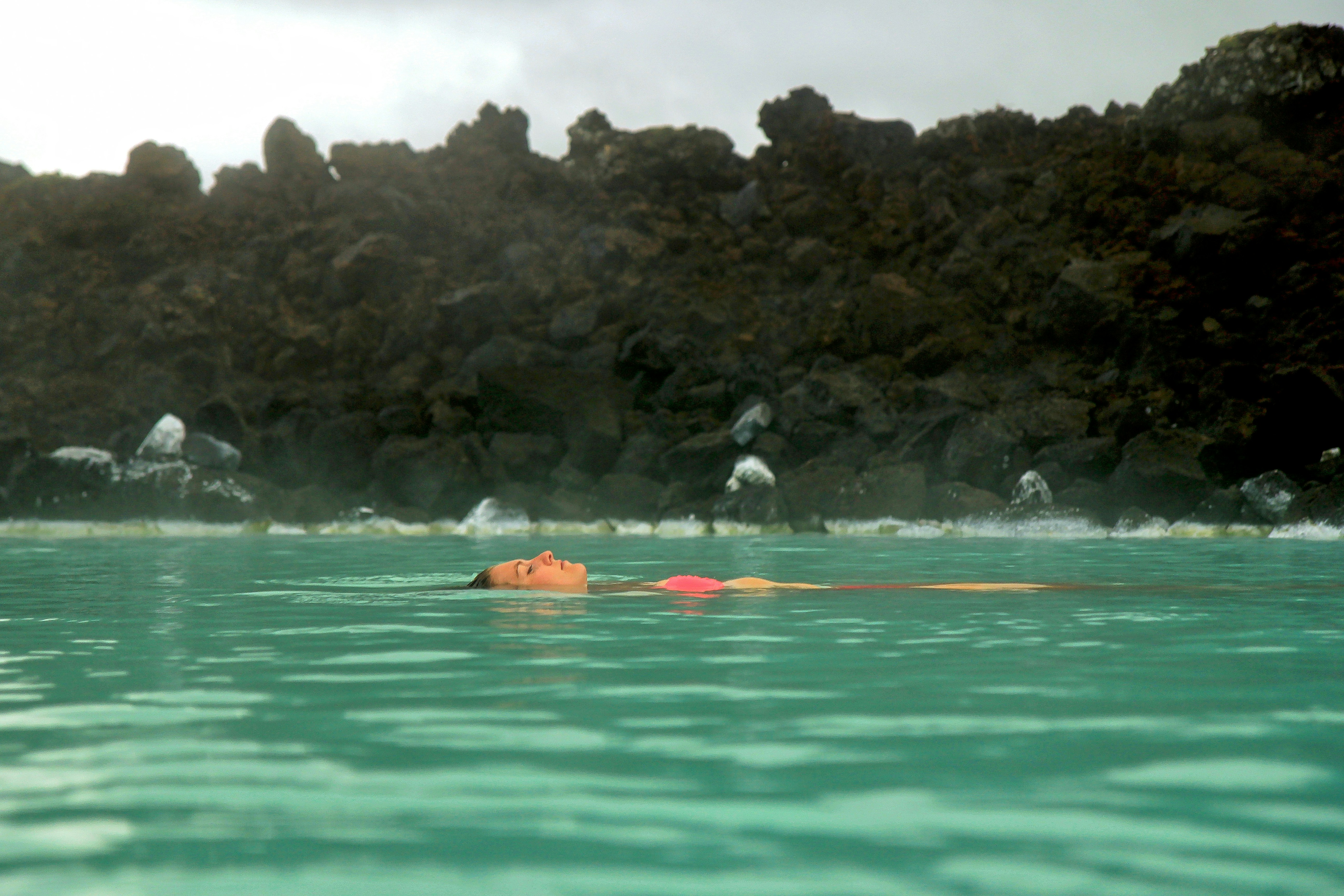 people swimming in the lake during daytime