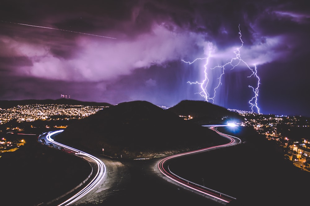 time lapse photography of road and mountains during night time