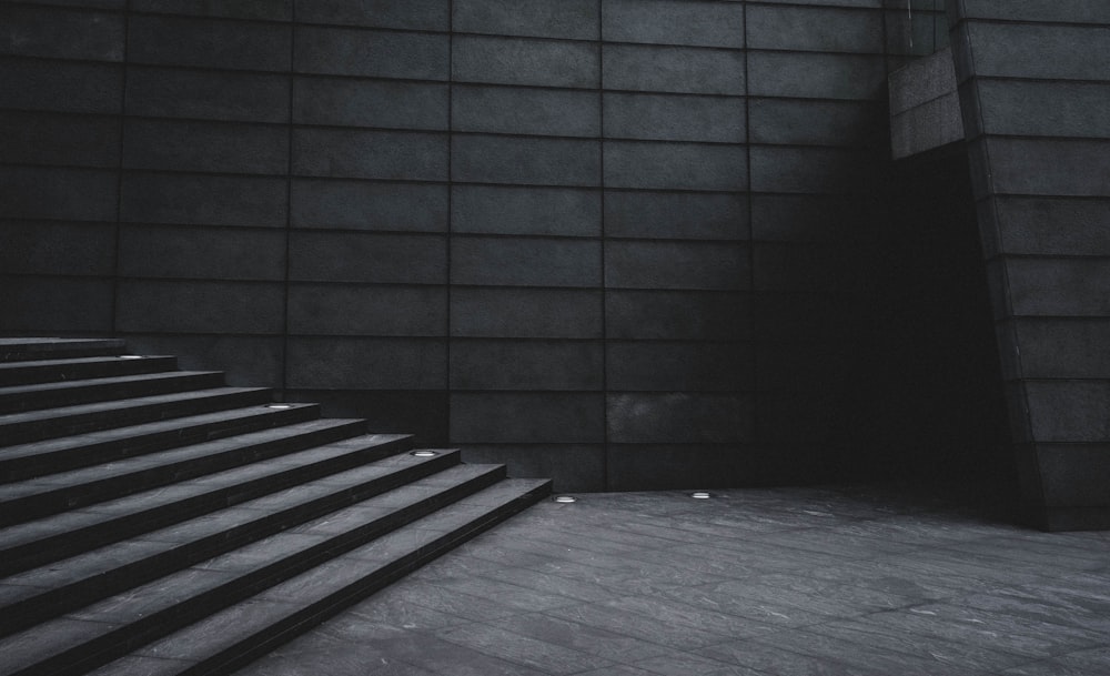 grayscale photo of stairs beside building