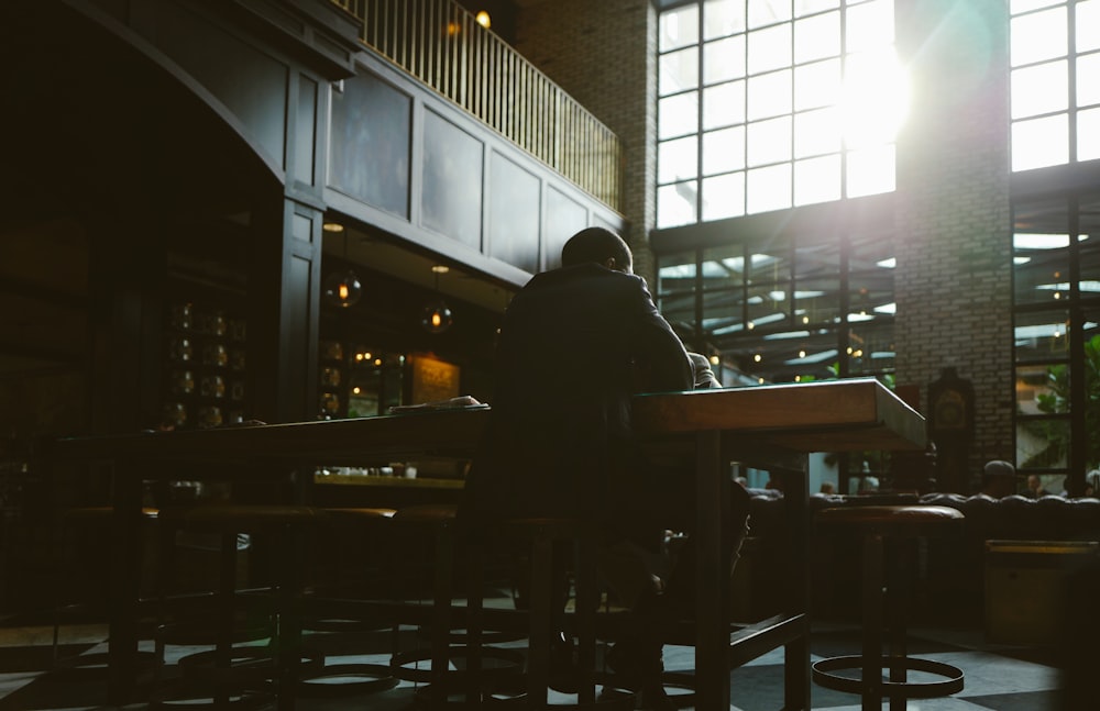 man seating on bar stool