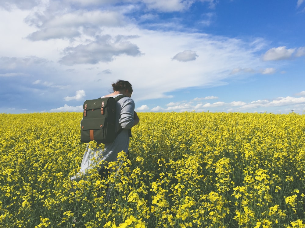 persona en un campo de flores amarillas durante el día