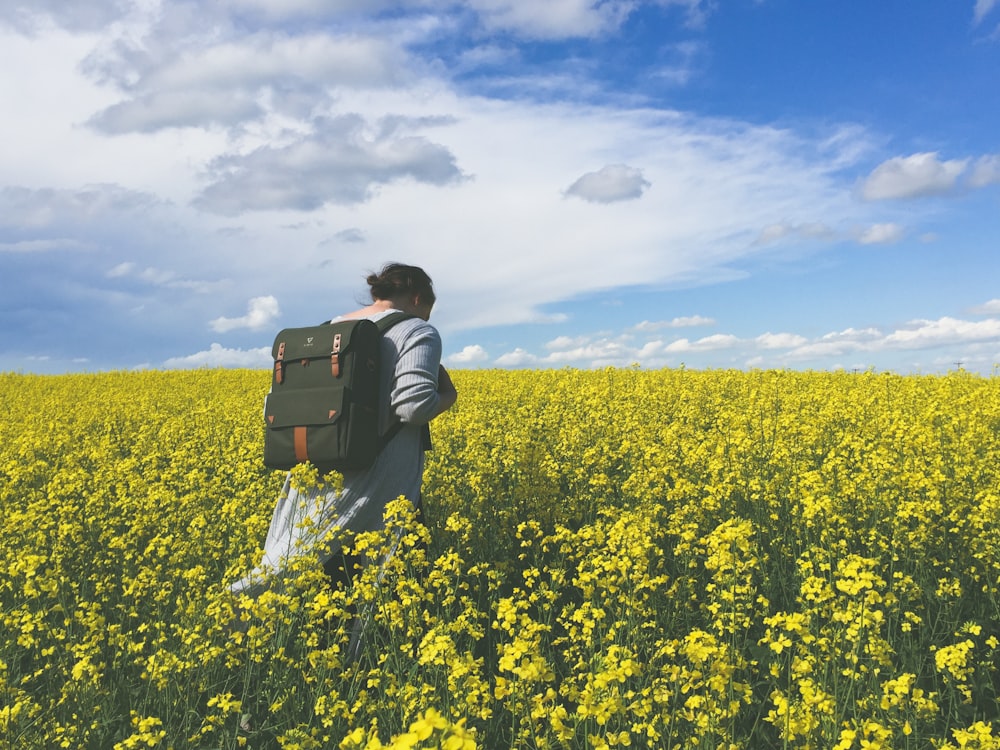Person in einem gelben Blumenfeld während des Tages