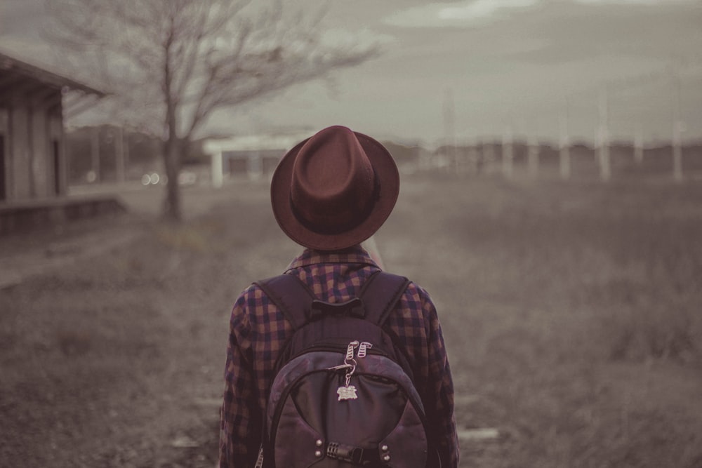 persona che indossa la fotografia ravvicinata del cappello marrone