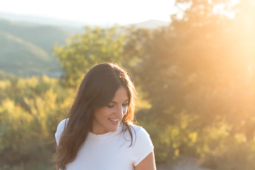 Tara Hayes smiling warmly during a wellness retreat, surrounded by nature.