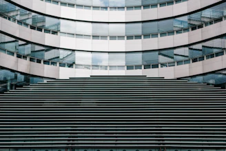 A sleek modern building facade featuring aluminum doors and glass curtain walls reflecting the Qatari skyline.